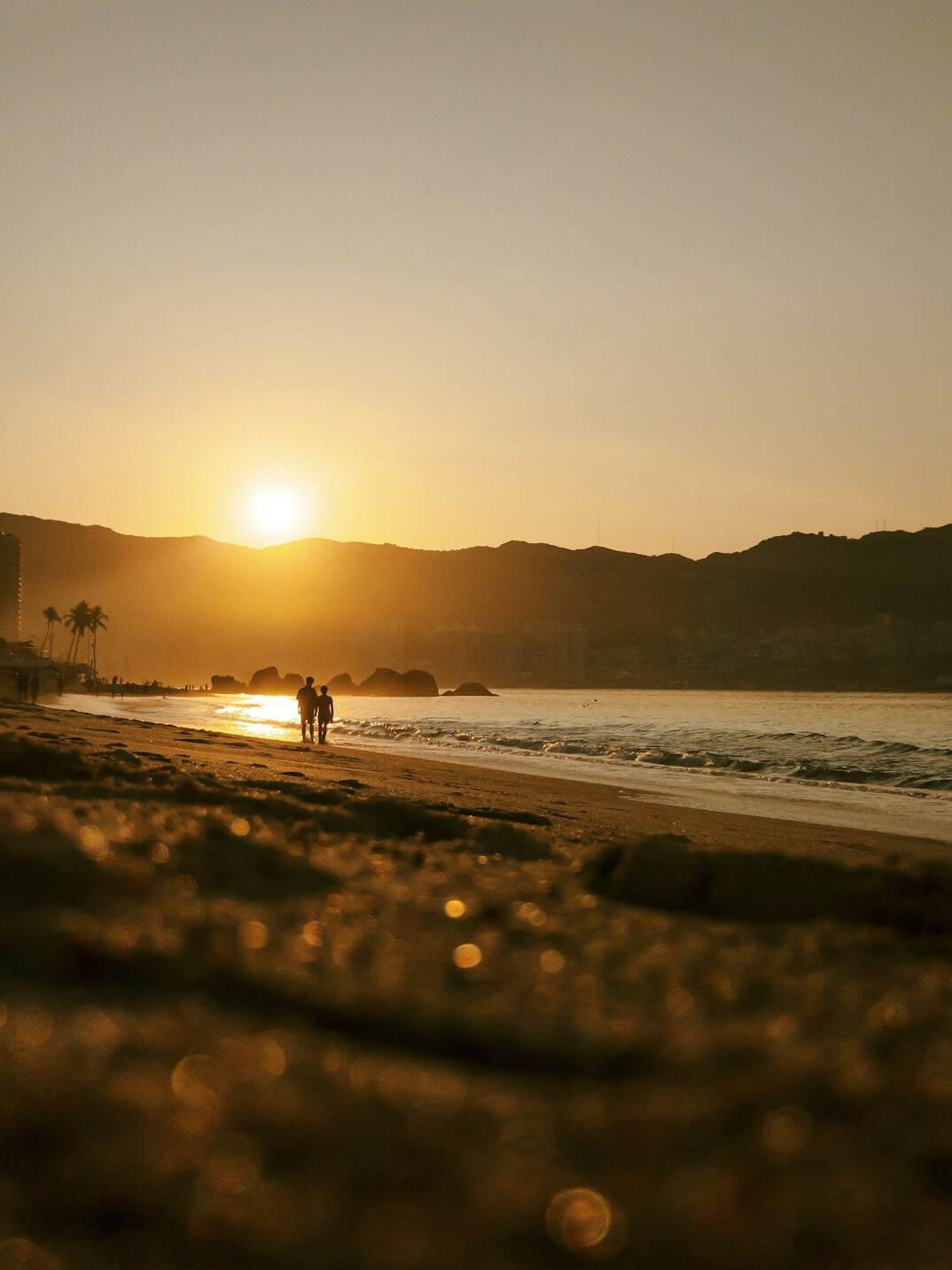 person walking beach sunset